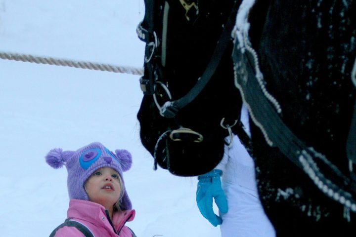 a little girl that is standing in the snow